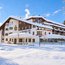 Das verschneite Hotel Der Leutascher-Hof vor blauem Winterhimmel